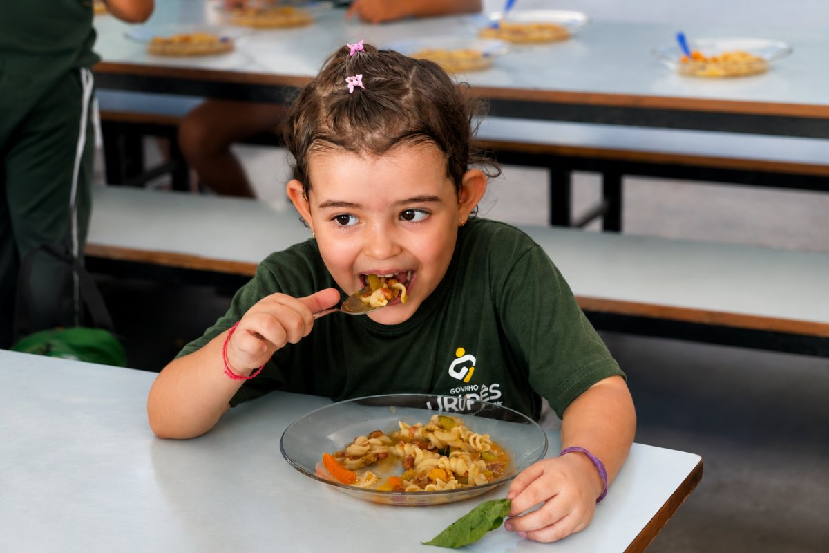 Criança da EMEI Thereza Yalenti Perosa comendo nova merenda escolar. Foto: Natália Bertoli / Prefeitura Municipal de Urupês.